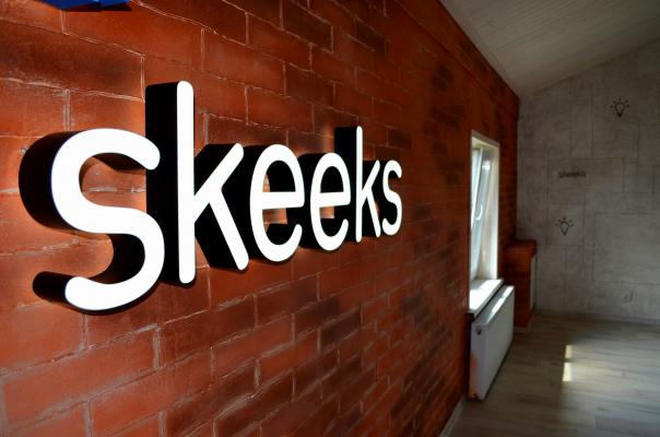 Oficina actualizada skeeks. Logo resplandeciente en la pared.